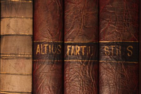 Stacked vintage books in a dim library, spines facing outward