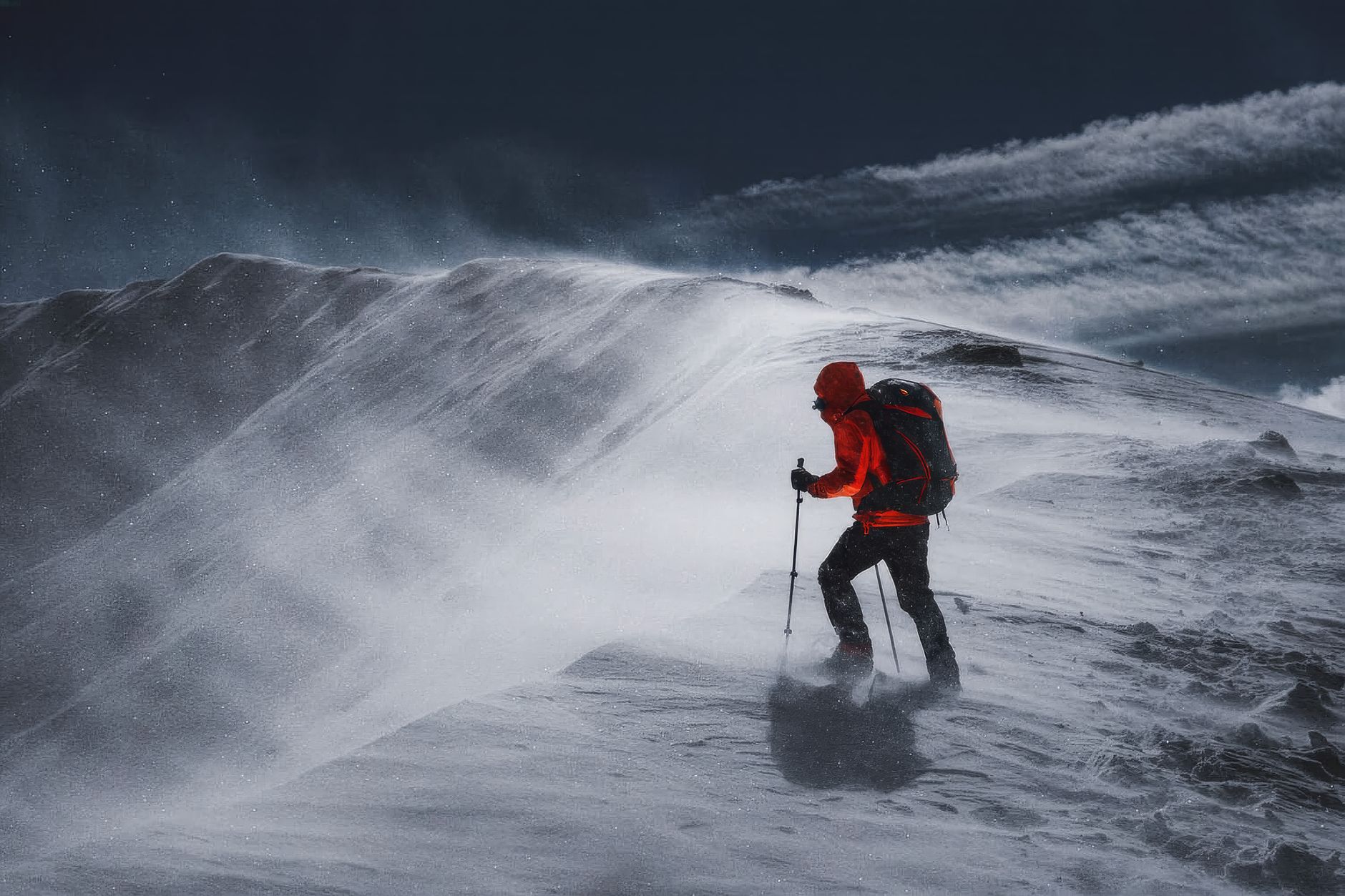 Rugged mountain landscape with dramatic weather, evoking survival conditions