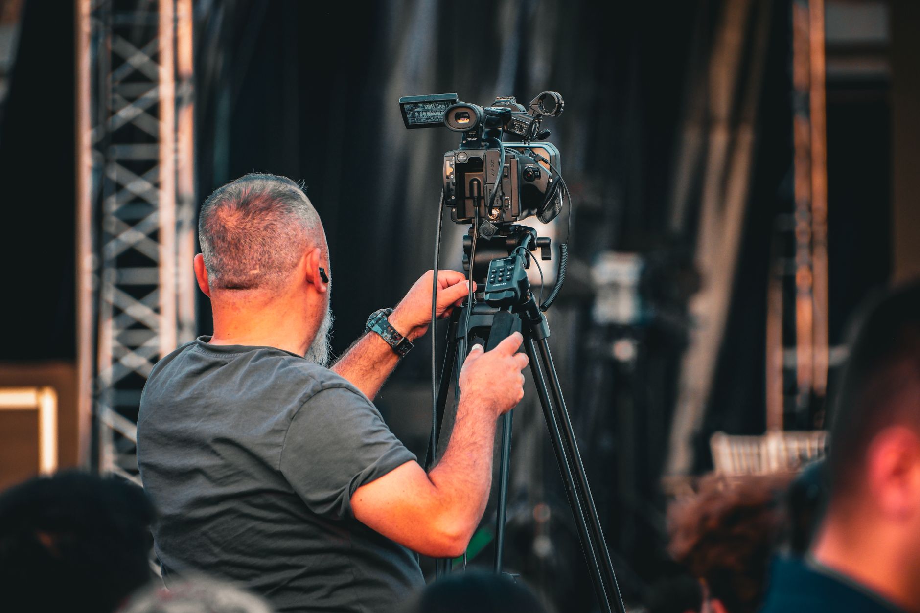 Filmmaker operating a documentary camera on location in a city setting