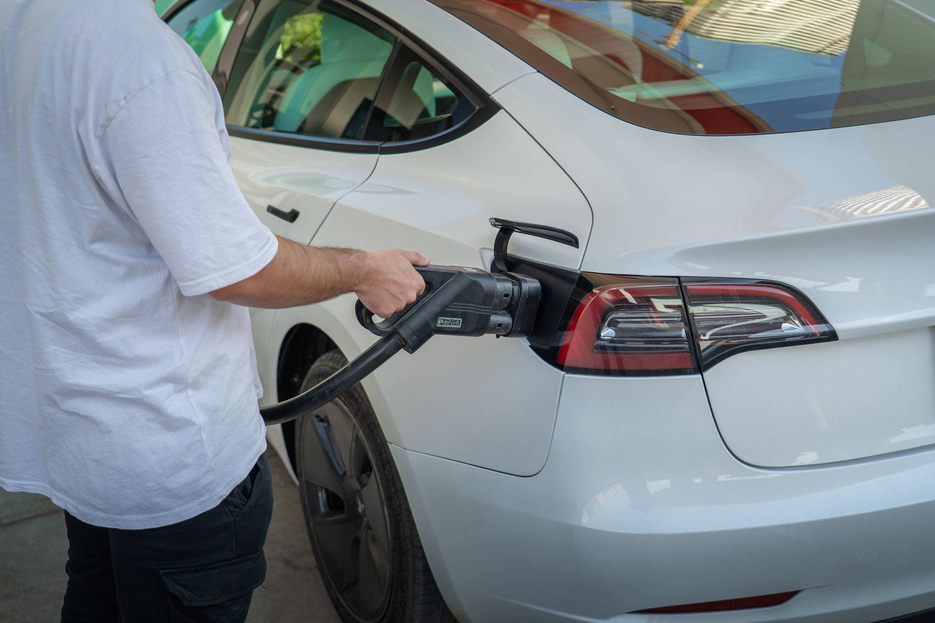 Plug-in hybrid vehicle connected to a charging station outdoors