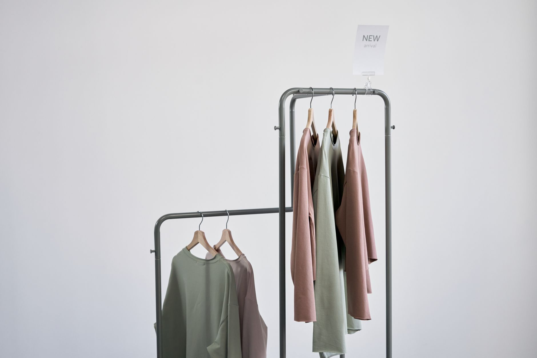 Clean minimal wardrobe with neutral-toned structured pieces folded and hung